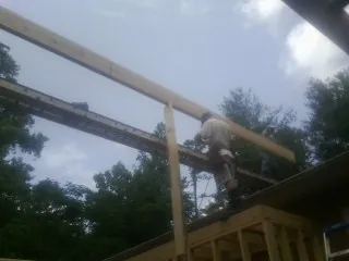 Carpenter setting a ridge beam over a new addition frame — Ice Dam Removal by Roofing Brothers in Charles Town