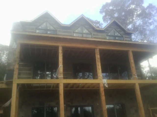 Dormers and porch framing on a large log home under construction — Roof Coating work by our crew in Charles Town