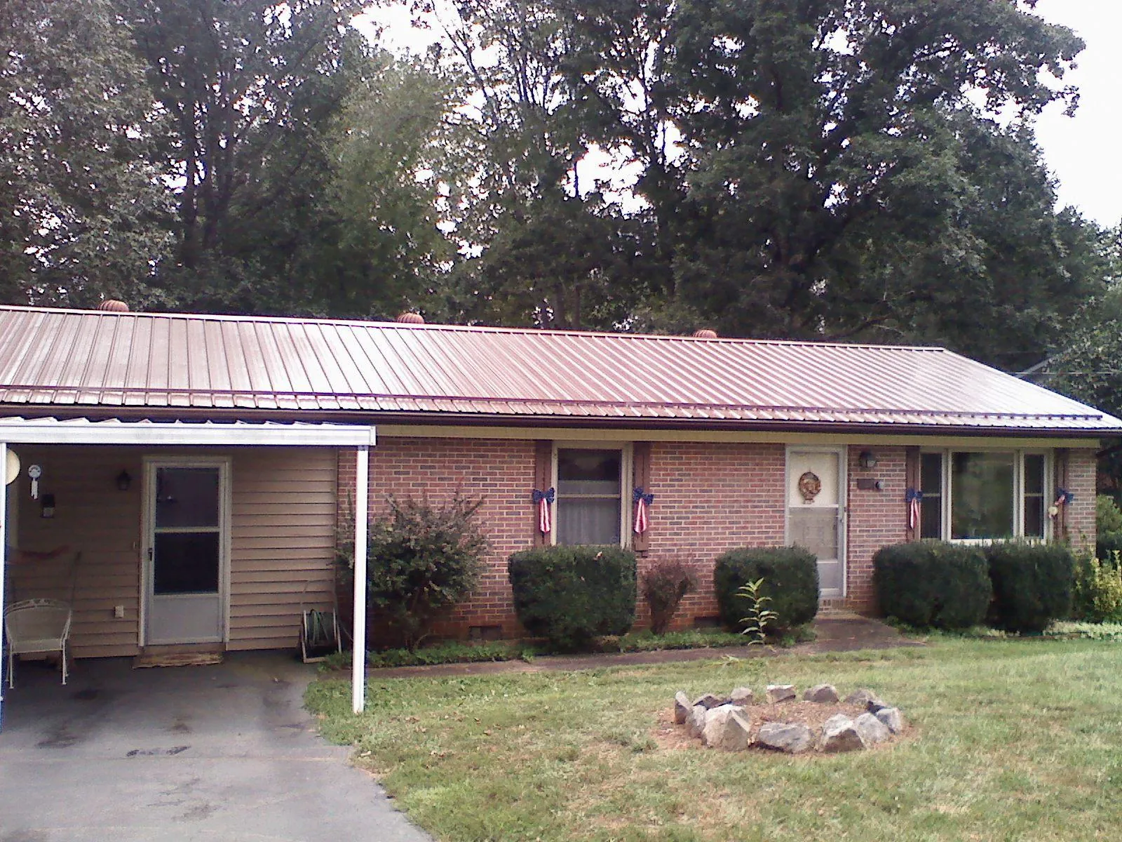 Bronze metal roof and carport on a brick ranch home — Roof Repair work by our crew in Charles Town