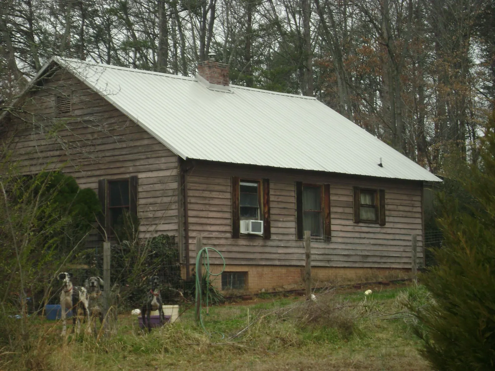 White metal roof on an old wood sided farmhouse, from a Metal Roof Installation job in Charles Town